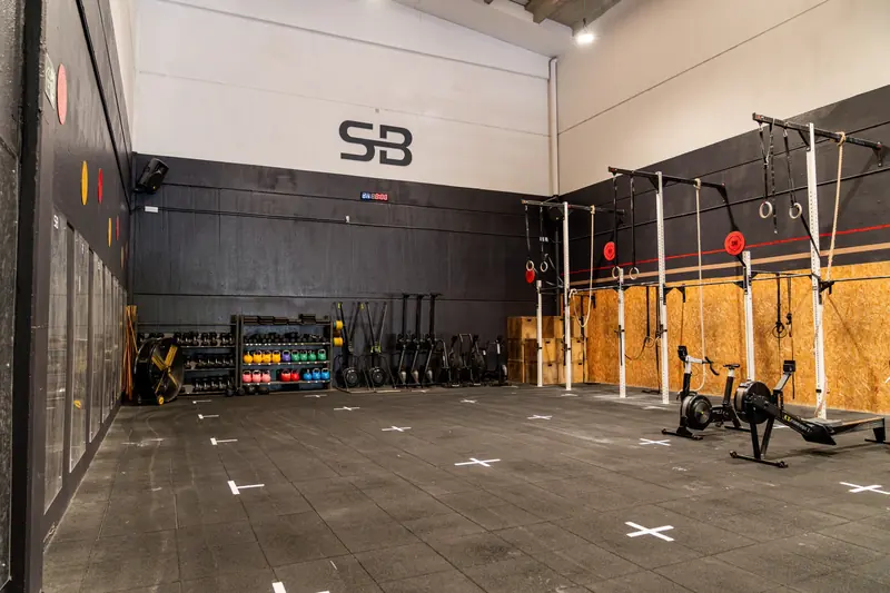 Sala principal del box con el logotipo SB, rig y máquinas de cardio