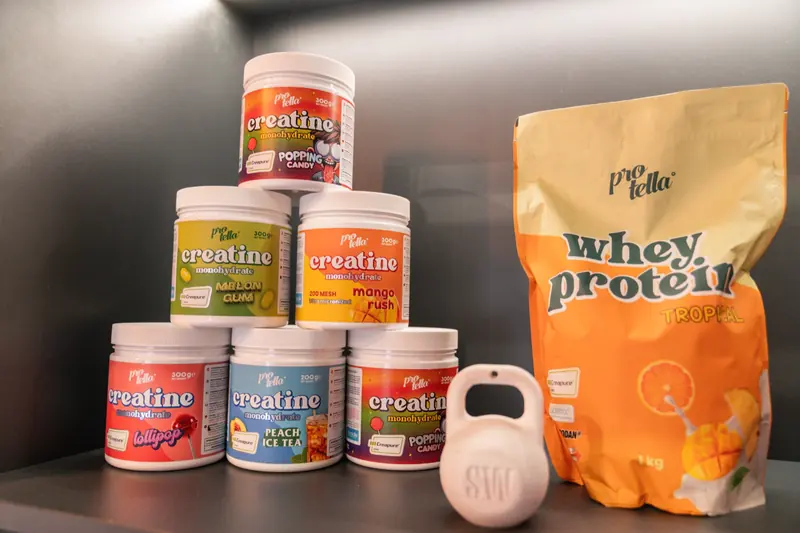 Botes de creatina, proteína y una kettlebell en recepción